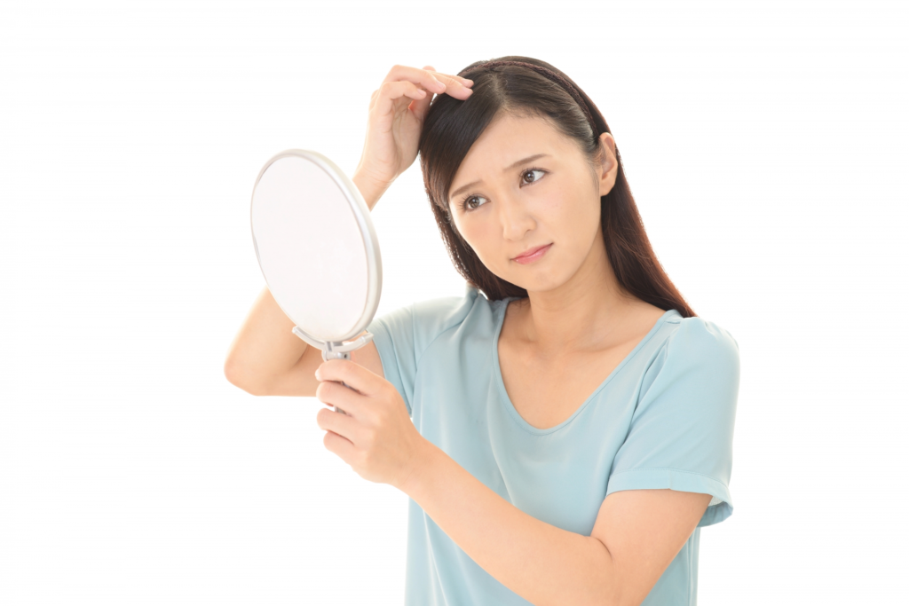 髪の毛を気にする女性のイメージ画像